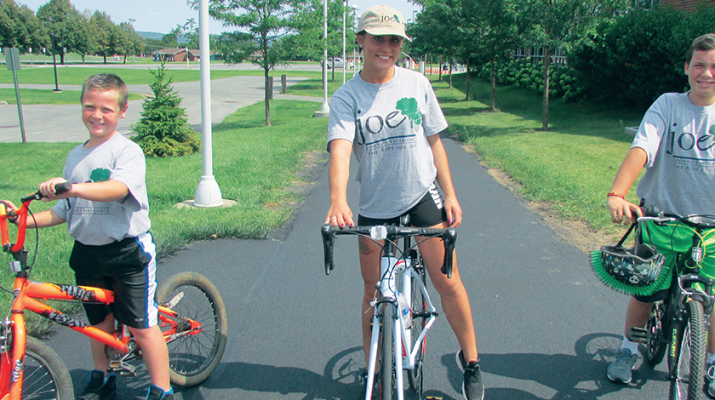 Sarah Bostick, a leukemia survivor, rides on the Mohawk Valley Community College campus with Dominick Klar during the reception for participants in the third annual “Ride for Joe.”