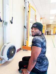 Kevin Burnside, Paralympic hopeful, works out on the ERG machine and bench press at Sitrin Rehabilitation Center in New Hartford.