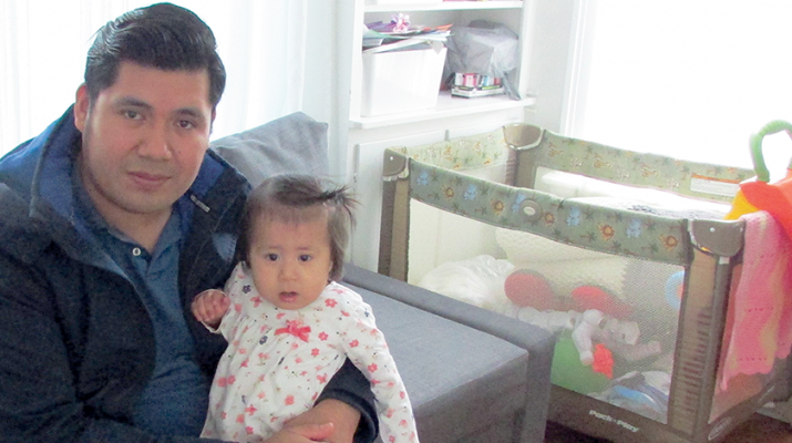 Angel Ramirez holds his baby girl, Ariana, in their home in west Utica.