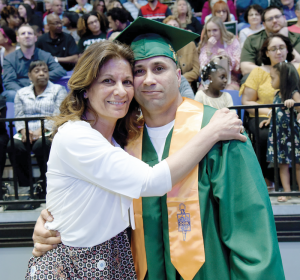 Decked out in his graduation garb, Mohawk Valley Community College student Jayson Julian spends a special moment with his mother, Karen.