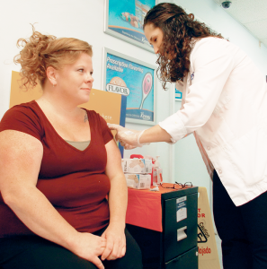 Caitlin Pohleven, supervising pharmacist at Kinney Drugs in Little Falls, administers a flu vaccine to a patient.