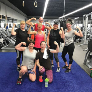 Members of a group fitness class flex their muscles at Revamp Fitness in Herkimer.